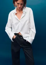 Pantalón de jean estilo wide leg de tiro medio, con diseño de cinco bolsillos, trabillas para cinturón y cierre frontal con botones.