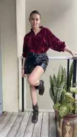 Buzo negro de terciopelo con escote en V y bolsillos frontales.