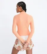 Polera color camel de punto acanalado, con cuello alto y mangas largas.