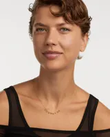 Collar dorado con cadena fina y ocho colgantes de circonitas cúbicas multicolores.