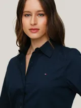 Camisa azul marino de popelín de mezcla de algodón elástico, corte regular, cuello inglés, puños con botón y logo de Tommy Hilfiger bordado en el pecho.