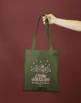 Tote bag de color beige con estampado gráfico en color verde que ilustra un perro con lentes sobre una manta, acompañado por la frase 'Otoño Uruguayo'. Cuenta con doble asa larga para llevar al hombro.