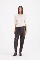 Pantalón de cuero sintético en color marrón oscuro, de corte holgado con cintura alta y cinto ajustable del mismo material.