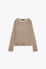 Jersey de punto efecto doble, color azul marino con detalles en blanco en el cuello, puños y ruedo. Presenta cuello redondo y manga larga con diseño de hombros raglán.
