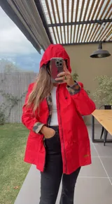 Piloto de lluvia impermeable color rojo con capucha y puños con estampado animal print.