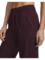 Pantalón deportivo Under Armour Unstoppable Wvn color bordó, de corte relajado, con cintura elástica con cordón de ajuste y puños elásticos en los tobillos.