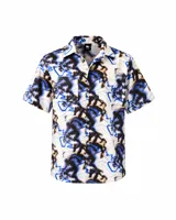 Camisa de manga corta de calce relajado, con cuello clásico, cierre frontal con botones y bolsillos aplicados en el pecho. Presenta un estampado integral abstracto en tonos crudo, negro, marrón y azul eléctrico.