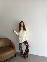 Pantalón tipo oxford de tiro alto, con estampado abstracto en tonos tierra, negro y crema. Presenta un corte ajustado en la parte superior y acampanado desde la rodilla hacia abajo.