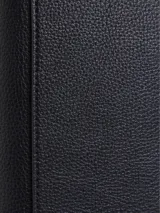 Billetera Calvin Klein trifold de poliuretano negro con textura granulada y placa metálica con logo CK. Cuenta con diez ranuras para tarjetas, billetero, compartimento para el DNI y bolsillo monedero.
