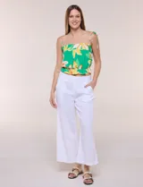 Pantalón crop de lino y rayón, con diseño wide leg de corte holgado, estampado tropical de hojas en tonos verde, azul y marrón sobre fondo blanco. Cuenta con pretina trasera elastizada y bolsillos delanteros.