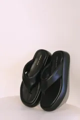 Sandalias negras de cuero sintético con plataforma y diseño de tanga.