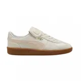 Championes Puma modelo Palermo Premium, color blanco hueso con detalles en beige y suela de goma color caramelo. Diseño clásico de perfil bajo con logo dorado en el lateral.