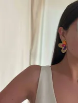 Aros dorados con forma de flor, con cristales facetados de vidrio en color naranja, fucsia y violeta.