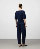 Pantalón jogger de punto color azul marino, de corte relajado y tiro alto, con pliegues frontales y puños ajustados en el tobillo.