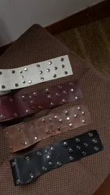 Faja de ecocuero con diseño de tachas metálicas circulares distribuidas por toda la superficie. Accesorio versátil de 8 cm de ancho, ideal para ajustar y definir la cintura.
