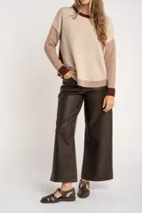 Sweater de punto con diseño color block en tonos beige, marrón y bordó, de cuello redondo y manga larga con puños acanalados en contraste.