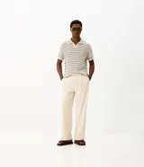Pantalón de vestir beige de corte wide leg, con trabillas para cinto, bolsillos y diseño de sastrería.