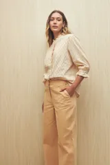 Pantalón wide leg color crudo, de tiro alto, con grandes bolsillos laterales y traseros.