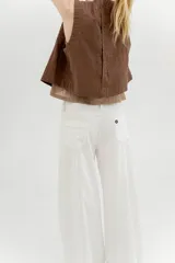 Pantalón de tiro medio y piernas anchas, confeccionado en mezcla de lino y algodón, con bolsillos delanteros y traseros con detalles de costuras pespunteadas a contratono.