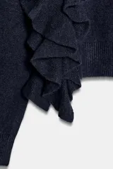 Jersey de punto color azul marino, con cuello redondo, manga larga y volantes decorativos en el frente y los hombros.