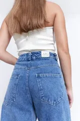 Top strapless de satén color bronce, con diseño de nudo frontal y drapeado estructurado.