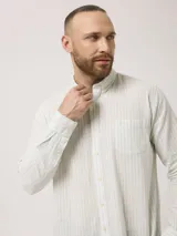 Camisa de hombre de manga larga con rayas verticales en tonos verde claro y blanco. Confeccionada en una mezcla de lino y algodón, presenta cuello abotonado y bolsillo en el pecho.