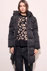 Tapado negro largo con capucha, diseño capitoneado y cierre frontal con botones dorados.