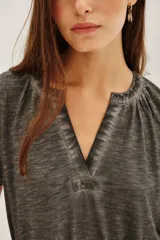 Remera de algodón y modal con efecto lavado, cuello en V con detalle de frunces y mangas cortas.
