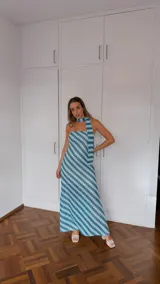 Vestido largo sin mangas, con escote palabra de honor y pañuelo incorporado al cuello. Presenta un estampado geométrico en tonos celeste, verde y blanco, con aberturas laterales en la falda.