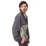 Campera rompevientos Rusty modelo Pipper, con diseño color block en tonos gris y verde oliva. Presenta cierre frontal, capucha, puños elásticos y logo de la marca bordado en el pecho.