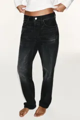 Jeans de tiro medio con corte straight, color azul con efecto lavado y roturas sutiles, cinco bolsillos y cierre frontal con cremallera y botón metálico.