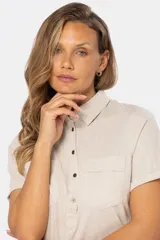 Camisa de lino de manga corta con medio cierre de botones frontales, cuello clásico y dos bolsillos en el pecho.