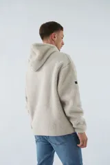 Canguro de sherpa polar color beige, con capucha, bolsillo tipo canguro y logo de goma en el pecho.