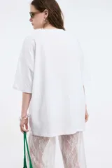 Remera oversize gris oscuro con cuello en V y mangas cortas. Presenta una estampa frontal estilo universitario con el número "09" y las inscripciones "MVD", "UY" y "PIMENTÓN ACTIVE" en tonos celestes y blancos.