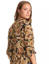 Blusa de gasa marca Floral & Ivy con estampado de arabescos en tonos tierra. Presenta cuello a la base con escote en V, mangas tres cuartos con sistema de ajuste mediante presilla y botón.