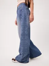 Jean wide leg de tiro alto color celeste, con diseño estampado tipo paisley en los laterales de las piernas.
