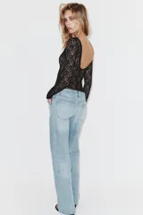 Jeans de tiro bajo con diseño wide leg y corte full length. Presenta cinco bolsillos, cierre frontal con cremallera y botón metálico, en un lavado de denim claro.