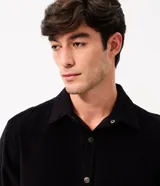 Camisa de terciopelo cotelé color negro, de corte clásico con cuello solapa, manga larga, cierre frontal de botones y un bolsillo aplicado en el pecho.
