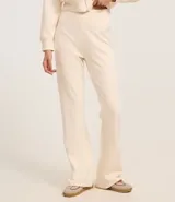 Pantalón flare color crema confeccionado en algodón con viscosa certificada, forro en fleece y cintura elástica.