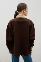 Campera de jean azul oscuro con cuello de pana en color crema. Presenta cierre frontal metálico, bolsillo con cierre en el pecho y bolsillos laterales. Diseño de corte holgado con mangas largas.