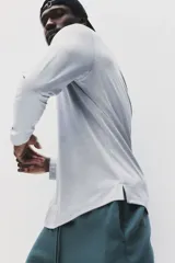 Remera deportiva de manga larga con cuello redondo, confeccionada en tejido funcional transpirable con tecnología DryMove que absorbe el sudor. Presenta un diseño liso con aberturas laterales en el bajo y corte estándar.