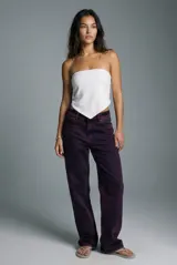 Top tipo bandeau blanco, ajustado al busto, con un corte inferior en forma de pico o pañuelo.