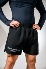 Short deportivo negro con cintura elástica, bolsillos laterales y estampado con la frase "Strength in every step Hermod" en la pierna izquierda.