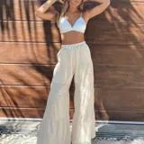 Pantalón beige de corte palazzo, con cintura elástica y diseño escalonado.