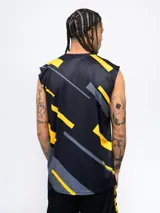 Musculosa de entrenamiento negra con estampado geométrico en amarillo y gris, y el escudo de Peñarol en el pecho.