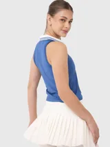 Top deportivo sin mangas con cuello polo y escote en V, diseñado con tecnología de secado rápido. Presenta un diseño bicolor en azul y blanco con detalles de rayas en el cuello.