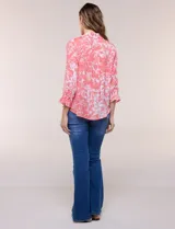 Blusa celeste con estampado efecto pincelada blanca, de corte semi holgado, escote en V con cuello solapa y media abotonadura frontal con botones nacarados. Presenta finas alforzas verticales en la pechera y mangas 3/4 con puños elastizados.