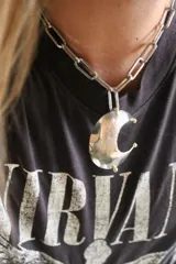 Collar plateado con cadena de eslabones grandes y dije de luna creciente texturizada. El dije está hecho de alpaca y bronce.