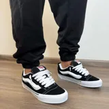 Pantalón de jogging negro con puños elásticos y estampado frontal con la leyenda "Buena Vibra Est. 2018".