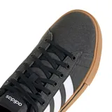 Championes urbanos Adidas Daily 4.0, color negro con las tres tiras laterales en blanco y suela de goma color caramelo. Presentan capellada de tela con cordones negros y diseño de plataforma baja.